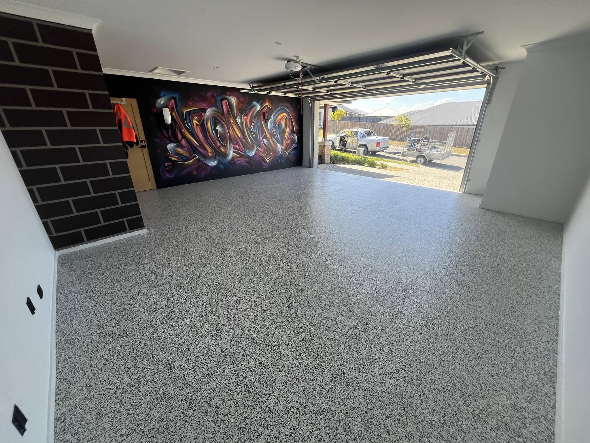 Custom flake garage floor with graffiti feature wall