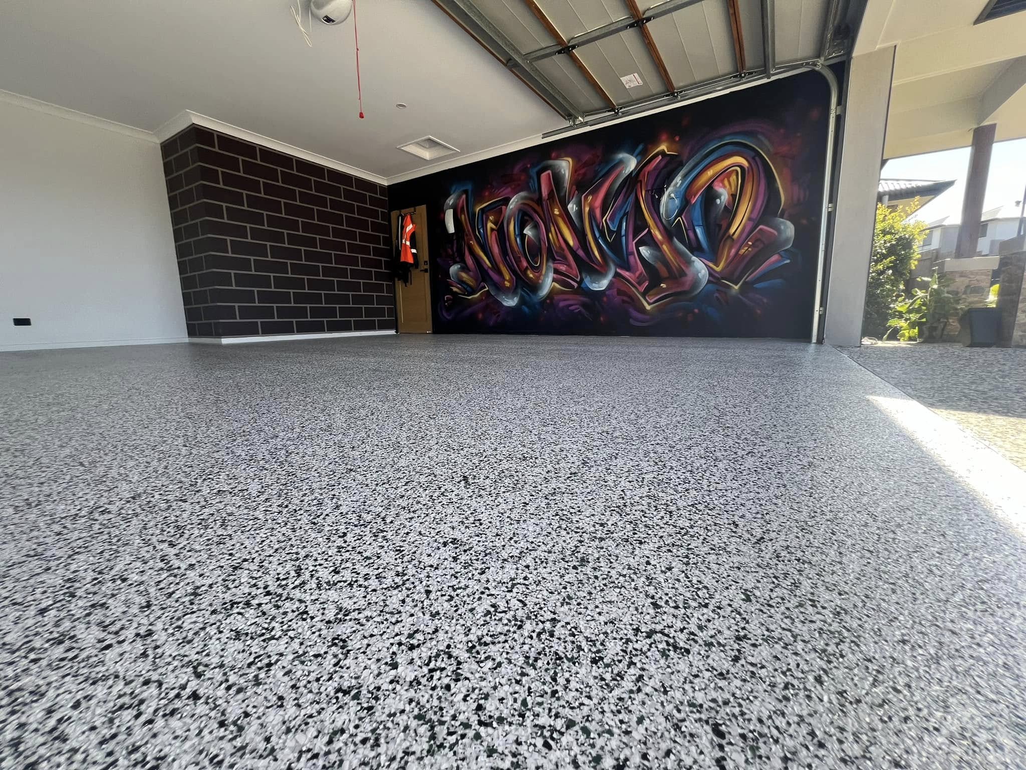 Wide-angle flake garage with graffiti feature wall — completed by Primal King
